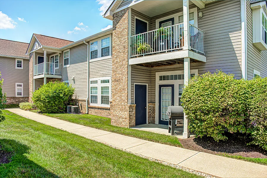 Balconies and patios like these at Bayshore Apartments become a cozy spot when you add plants, furniture, or a grill. An exterior view of apartment patios and balconies with plants and a grill on them at Bayshore Apartments