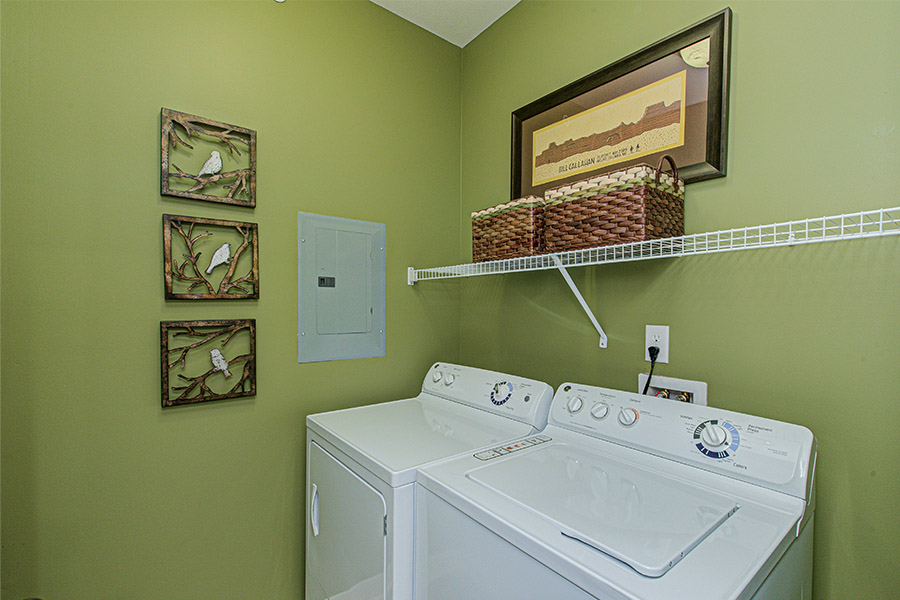 Look for an apartment with ample storage space like in this laundry room at Ivy Flats Apartments. Green laundry room with shelving storage located at Ivy Flats Apartments.