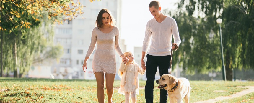 Family walking with their dog on neighborhood trail